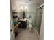 Bathroom with vanity, plant, and toilet, featuring neutral tile and shower with glass door at 7104 Blue Earth Ct, Orlando, FL 32818