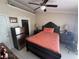 Bedroom featuring neutral walls, a ceiling fan, tile floors, and a dark wood bedroom set with bed and side tables at 7104 Blue Earth Ct, Orlando, FL 32818