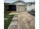 Exterior view of a one-story house with a one car garage, driveway, and a black metal door, and a white picket fence at 7104 Blue Earth Ct, Orlando, FL 32818
