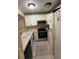 Galley style kitchen with white cabinets, stainless appliances, tile backsplash and tile floor at 7104 Blue Earth Ct, Orlando, FL 32818