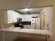 Cozy kitchen featuring white cabinets, stone-look countertops, stainless appliances, and a double basin sink with bar seating at 7104 Blue Earth Ct, Orlando, FL 32818
