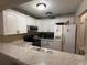 Cozy kitchen featuring white cabinets, stone-look countertops, stainless appliances, and a double basin sink at 7104 Blue Earth Ct, Orlando, FL 32818
