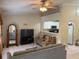 Cozy living room has open layout into kitchen with ceiling fan and tile flooring at 7104 Blue Earth Ct, Orlando, FL 32818