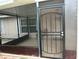 View of a screen enclosed patio with tile floor, metal door, and view of the side yard at 7104 Blue Earth Ct, Orlando, FL 32818