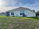 View of home's back exterior, featuring a screened in lanai and a spacious yard at 7172 Sw 135Th Pl, Ocala, FL 34473