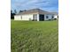 Spacious backyard with lush grass, views of the house, and covered patio at 7172 Sw 135Th Pl, Ocala, FL 34473