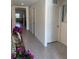 Hallway features modern tile flooring, neutral walls, and decorative floral accents on a console table at 7172 Sw 135Th Pl, Ocala, FL 34473