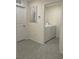 The functional laundry area includes a white washer and dryer, conveniently located near a hallway at 7172 Sw 135Th Pl, Ocala, FL 34473
