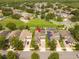 Aerial view of a two-story home with solar panels and a brick driveway in a residential neighborhood at 7214 Tattant Blvd, Windermere, FL 34786