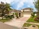 Charming home features a well-manicured lawn, brick driveway, and inviting facade at 7214 Tattant Blvd, Windermere, FL 34786