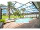 Screened-in pool area with a kidney-shaped pool with spa and surrounding trees at 7214 Tattant Blvd, Windermere, FL 34786