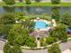 Aerial view of a community pool and clubhouse overlooking a lake with a fountain, surrounded by trees at 7214 Tattant Blvd, Windermere, FL 34786