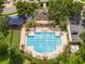 Aerial view of a community pool and clubhouse with lounge chairs, a playground, a putting green and parking area at 7214 Tattant Blvd, Windermere, FL 34786