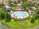 Aerial view of a community pool and clubhouse with lounge chairs, a playground, a putting green and a lake at 7214 Tattant Blvd, Windermere, FL 34786