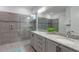 This spacious bathroom has double sinks, granite countertops, and a glass enclosed shower at 884 Golden Bear Dr, Reunion, FL 34747