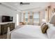The main bedroom features hard wood floors, a ceiling fan, a TV, and large windows at 884 Golden Bear Dr, Reunion, FL 34747