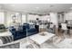 Open-concept living room with a large white coffee table, kitchen view, and modern furnishings at 884 Golden Bear Dr, Reunion, FL 34747