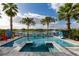 Inviting backyard oasis featuring a sparkling pool, serene lake view, playful games, and lush tropical landscaping at 884 Golden Bear Dr, Reunion, FL 34747