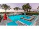 Sparkling pool features an attached spa, palm trees, playground amenity and comfortable deck chairs at 884 Golden Bear Dr, Reunion, FL 34747