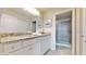 Bathroom featuring granite countertops, vanity mirror, and walk-in shower with glass door at 8900 Sydney Ave, Kissimmee, FL 34747