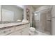 Well-lit bathroom with granite vanity, white cabinets, and a glass-enclosed shower stall at 8900 Sydney Ave, Kissimmee, FL 34747