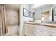 Bathroom featuring a double vanity, granite countertops, framed mirrors, and shower with curtain at 8900 Sydney Ave, Kissimmee, FL 34747