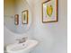 Bathroom features a white basin, decorative artwork, and a stylish round mirror at 8900 Sydney Ave, Kissimmee, FL 34747