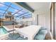 Covered patio features a dining table, chairs, pool view, and access to the outdoors at 8900 Sydney Ave, Kissimmee, FL 34747