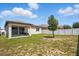 Backyard view features a well-maintained lawn, privacy fence, and a covered patio area at 914 Fallon Hills Dr, Haines City, FL 33844