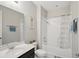 Bright bathroom with shower-tub combo with tile surround and a dark vanity at 914 Fallon Hills Dr, Haines City, FL 33844