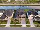 Aerial view of a gray two-story home with backyard pool and canal views at 9352 Santorini Dr, Orlando, FL 32827