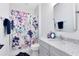 Bathroom with gray vanity, granite countertops, decorative mirror and white and floral shower curtain at 9352 Santorini Dr, Orlando, FL 32827