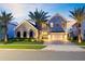 Beautiful exterior front of two-story home with palm trees, large windows and a driveway at 9352 Santorini Dr, Orlando, FL 32827