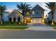 Beautiful exterior front of two-story home with palm trees, large windows and a driveway at 9352 Santorini Dr, Orlando, FL 32827