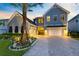 Exterior shot of a home at dusk, showcasing garage doors and a beautiful palm tree at 9352 Santorini Dr, Orlando, FL 32827
