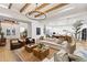 Spacious living room featuring wood beams, a modern chandelier, and views into the kitchen at 9352 Santorini Dr, Orlando, FL 32827