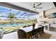 Luxury outdoor kitchen with seating area, grill, tv, and a view of the pool and putting green at 9352 Santorini Dr, Orlando, FL 32827