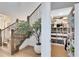 Inviting staircase features wood treads, black iron railings, and an elegant olive tree, enhancing the home's welcoming atmosphere at 9352 Santorini Dr, Orlando, FL 32827