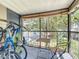 Cozy screened balcony with a table, chair, roll-up blinds, and bicycle storage at 950 Bird Bay Ct # 206, Lake Mary, FL 32746