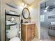 Bathroom featuring granite counters, framed round mirror, wood cabinets, and tiled floors at 950 Bird Bay Ct # 206, Lake Mary, FL 32746