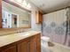 Bathroom featuring granite counters, wood cabinets, framed mirror, and tiled floors at 950 Bird Bay Ct # 206, Lake Mary, FL 32746