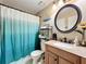 Bathroom featuring granite counters, framed round mirror, wood cabinets, and a shower with curtain at 950 Bird Bay Ct # 206, Lake Mary, FL 32746