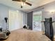 Cozy bedroom featuring soft carpet, ceiling fan, closet, and access to an outdoor balcony at 950 Bird Bay Ct # 206, Lake Mary, FL 32746