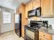 The kitchen offers modern black appliances, granite countertops, and wood laminate flooring at 950 Bird Bay Ct # 206, Lake Mary, FL 32746