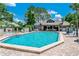 Community pool area featuring a large pool, seating, and a clubhouse in a lush setting at 950 Bird Bay Ct # 206, Lake Mary, FL 32746