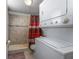 Bathroom with tiled walk-in shower, stackable washer, and dryer at 1000 S Semoran Blvd # 604, Winter Park, FL 32792