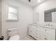 Elegant bathroom featuring double sinks, white cabinets, granite counters, and a walk-in shower at 1010 Leinhart Ct, Oviedo, FL 32765