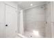 This bathroom boasts tiled walls, a mosaic tile floor, and a glass-enclosed shower for a sleek, modern design at 1010 Leinhart Ct, Oviedo, FL 32765