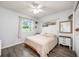 A cozy bedroom features a plush bed, a ceiling fan, wood floors, and natural light from the window at 1010 Leinhart Ct, Oviedo, FL 32765