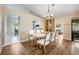 Bright dining room with wood floors, contemporary chandelier, and seating for six at 1010 Leinhart Ct, Oviedo, FL 32765